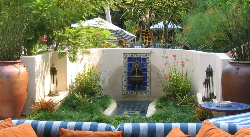 Environmentally sustainable CA garden with fountain, succulents and a couch that sits in on apatio 